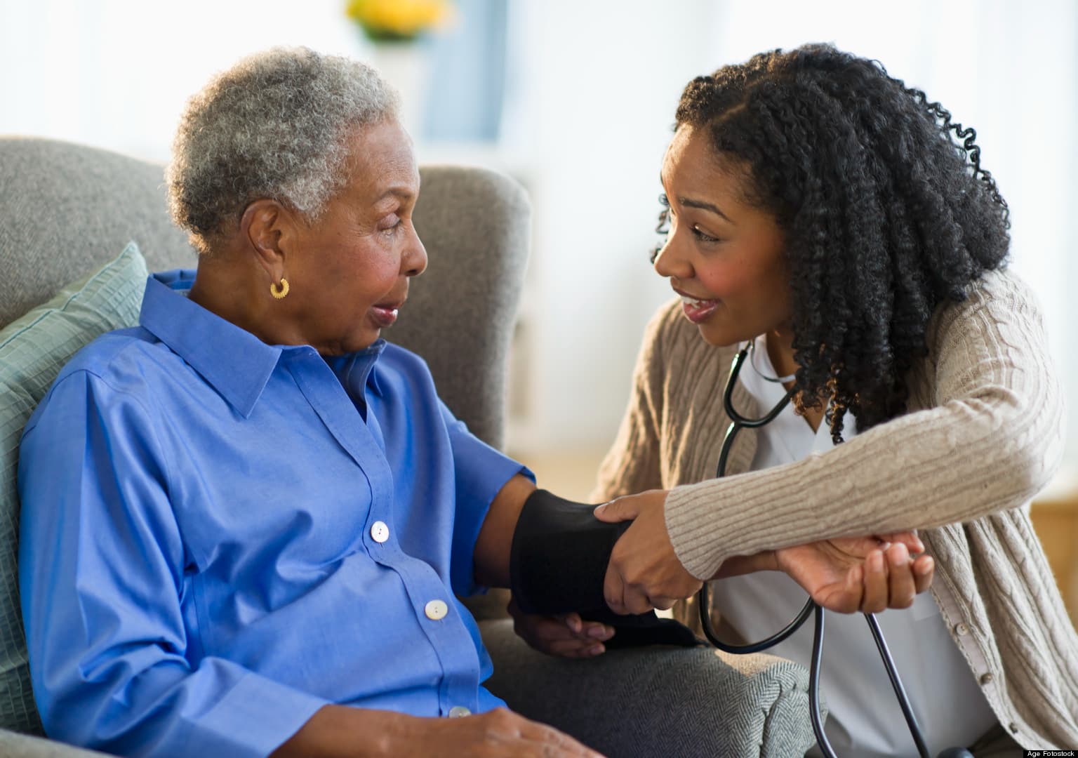 A care professional checks an older woman’s blood pressure.
